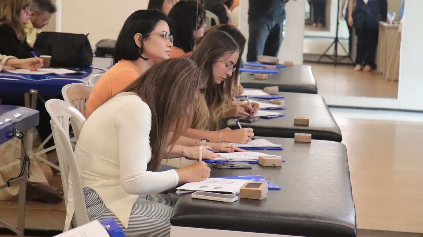 Alunas fazendo anotações durante o curso